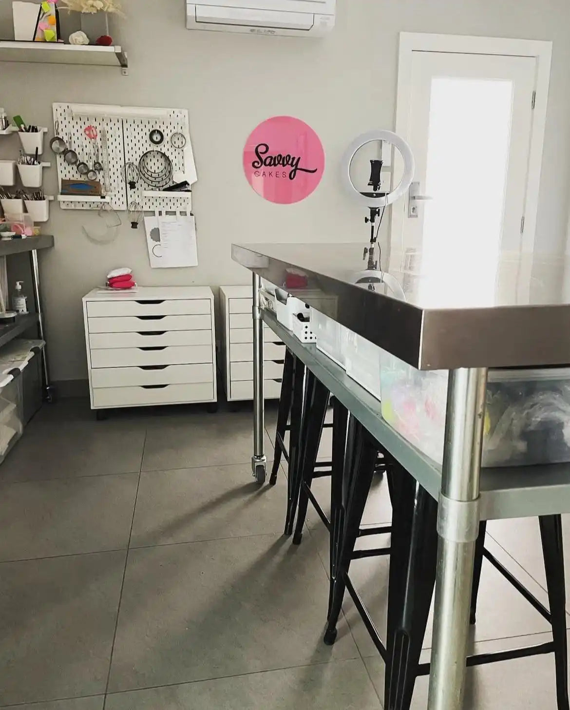 Stainless steel kitchen island with black stools.